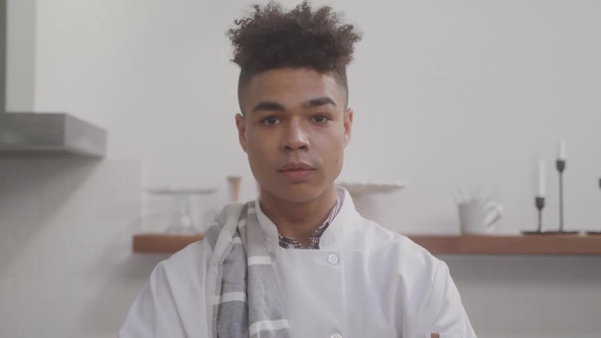 Portrait of a young man in a white chefs apron