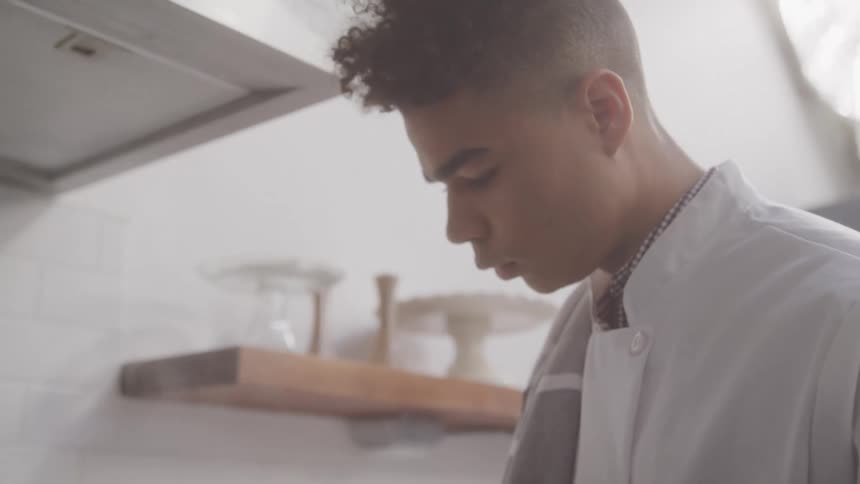 Portrait of a man looking down while standing in a kitchen