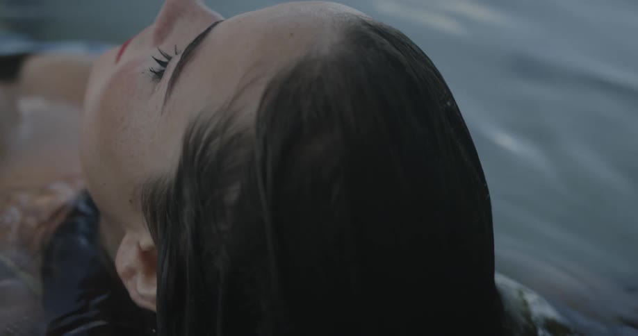 A woman floating in water lifts up her head