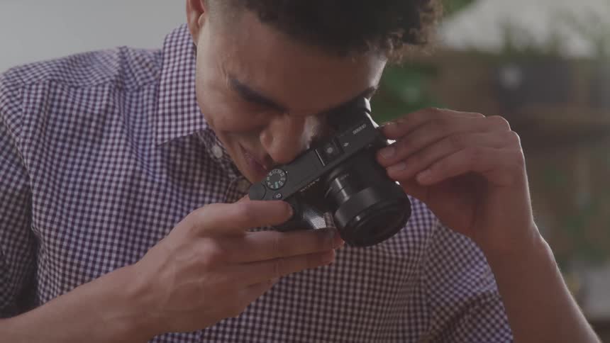 A young man takes a photo with a digital camera