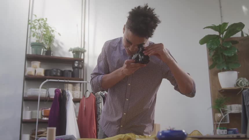 A tailor is taking photos of clothing