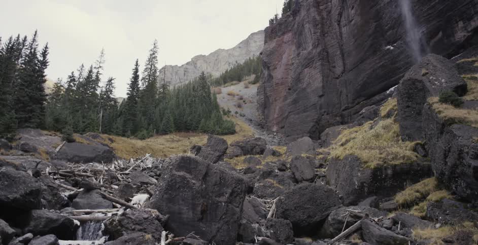 Water is flowing over a steep cliff and down a through rocks