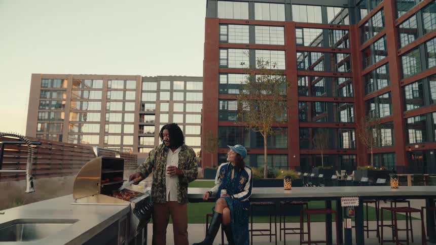 Woman and a man sitting outdoors having a barbecue
