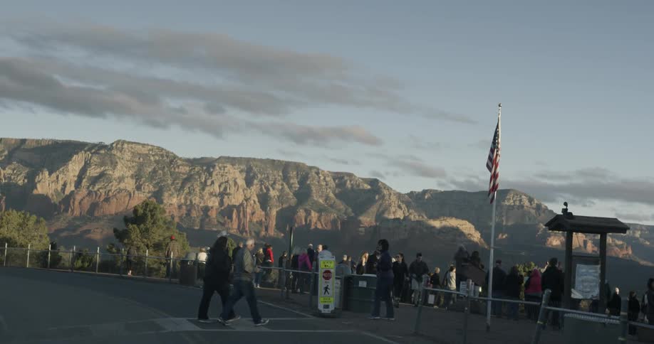 Crowds of people standing at lookout point looking out over mountains