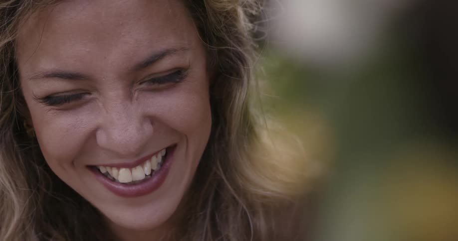 A woman is looking at someone and laughing