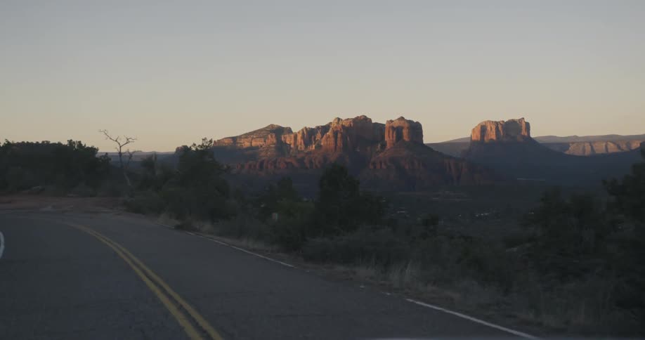 A view of traveling down the road and seeing mountains and trees