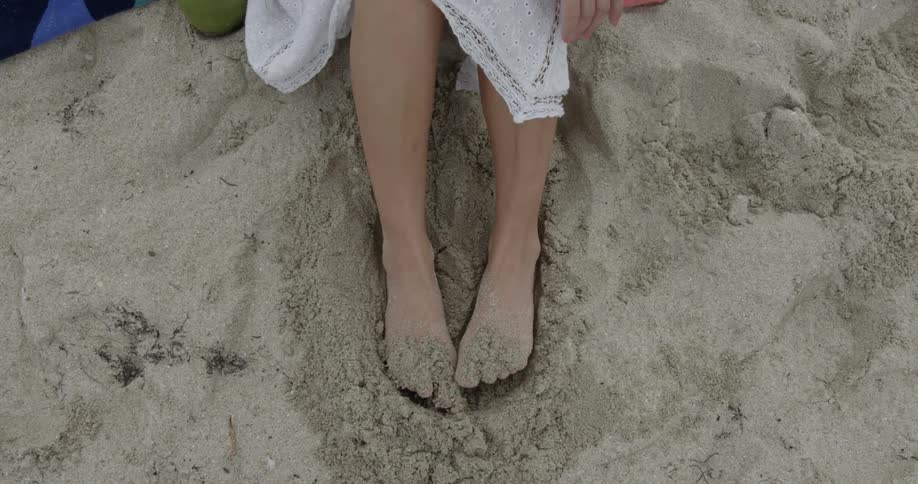 Woman digging her feet into the sand