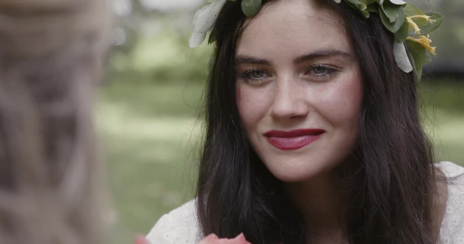 Woman wearing a flower reef on her head is smiling at another woman
