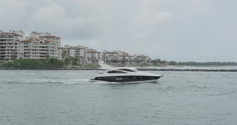 Boat traveling on ocean bay on overcast day