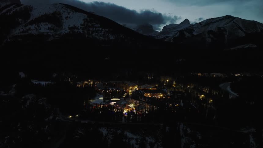 Cloudy mountains at dusk above Kananaskis Village in winter aerial view