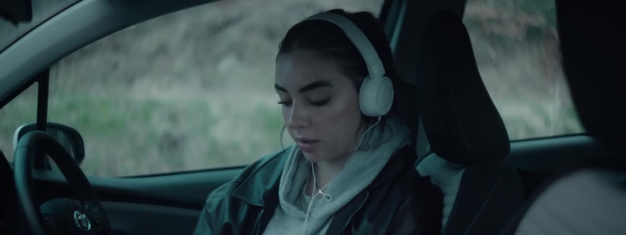 Woman sings while listening to music on her headphone in her car