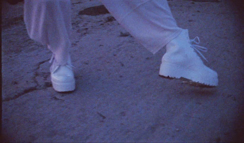Close up of a womans legs wearing white leather boots