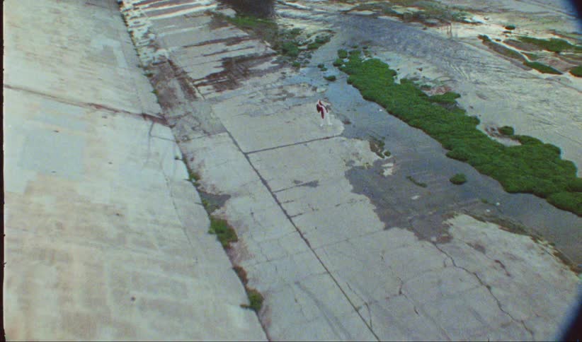 A woman is dancing near the water of the canal