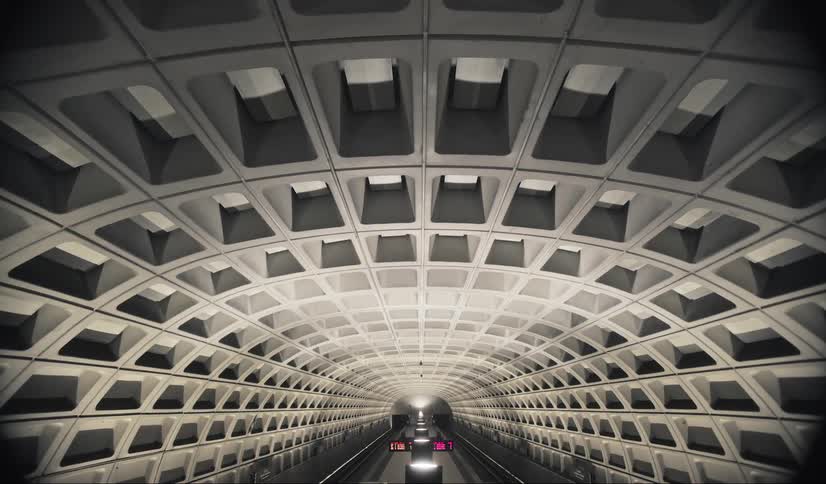 A long concrete tunnel has two displays by the paths