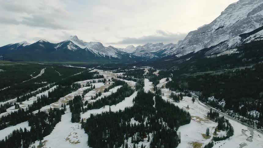 Aerial view of the Kananaskis river valley and mountain range covered in snow