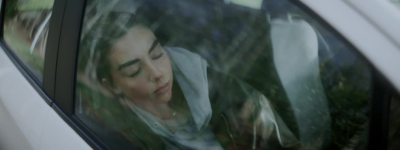 Woman sitting in the front seat of a vehicle sleeping