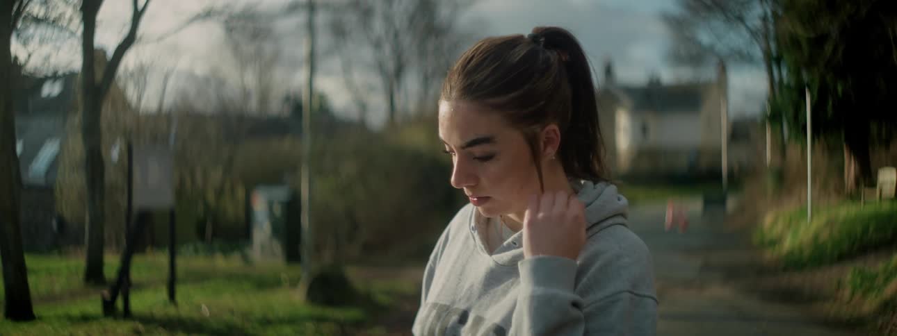 Woman fixing her hair while standing in an outdoor setting