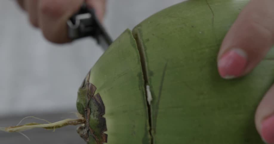 Woman using knife to cut into a piece of fruit