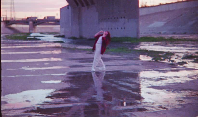 A woman is dancing by the overpass