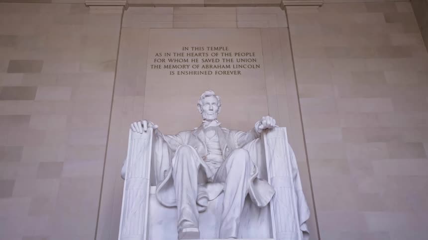 Statue of abraham lincoln at the lincoln memorial with an inscription to the memory of the president