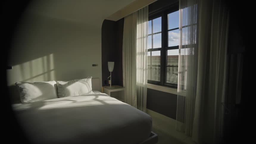Interior design of an organized bedroom with a window letting in the suns rays