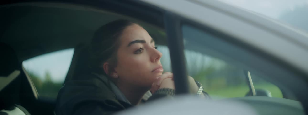 Woman sitting in a car thinking