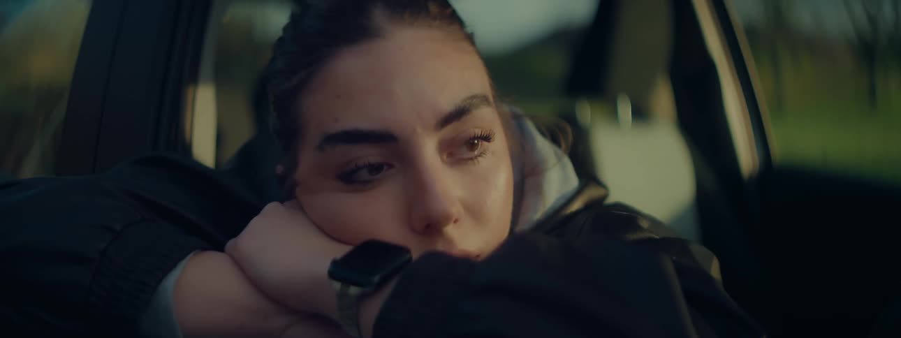 Sad woman leaning on car window contemplating
