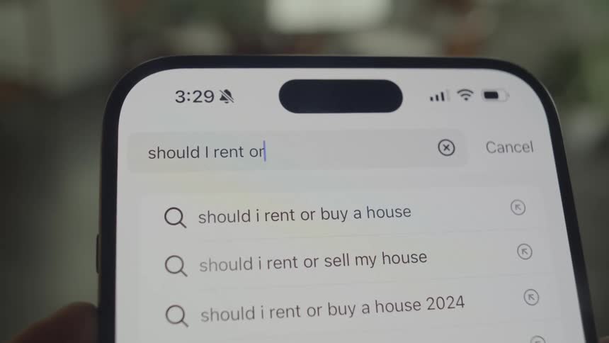 Someone off screen is typing into the open search bar on the smart phone