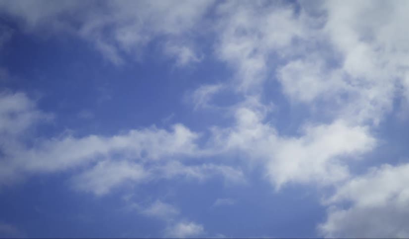 A timelapse of puffy white clouds moving across a bright blue sky