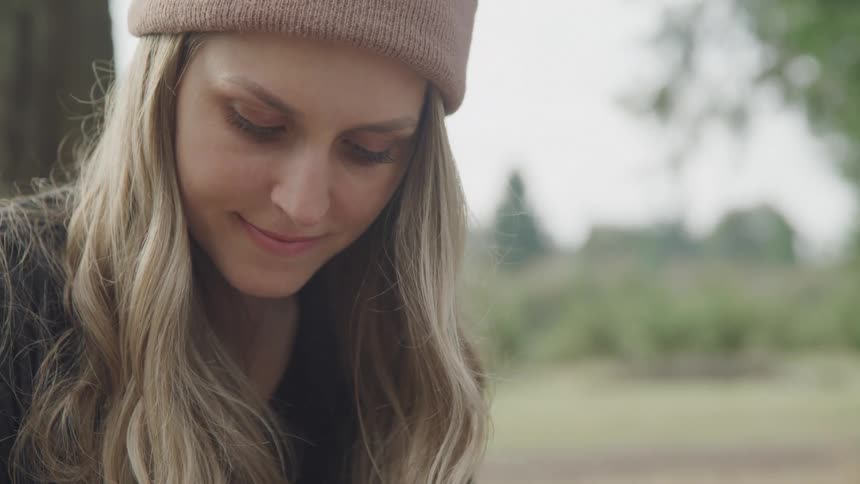 A woman smiles looking down