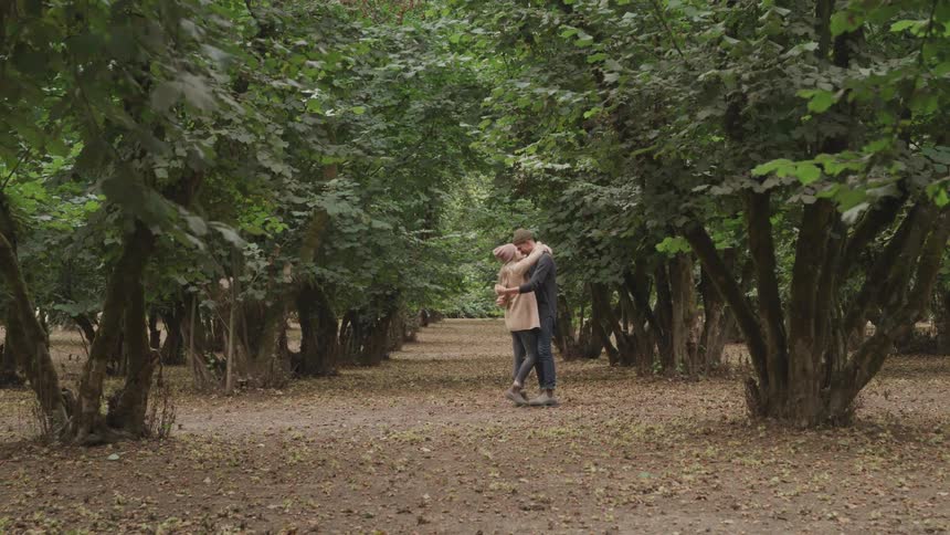 A man and woman hug in a park