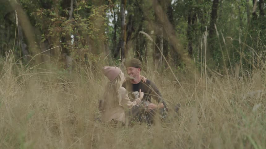 Man and woman hugging and smiling in the middle of a forest