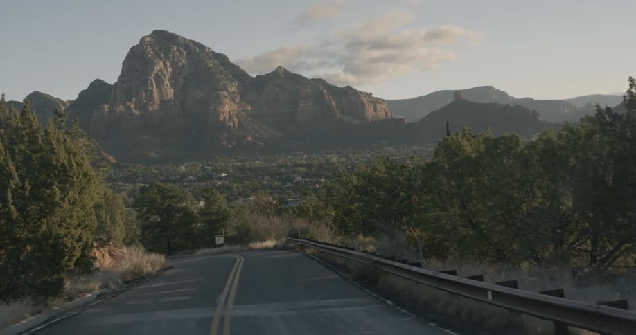 Curvy road winding through the land before some large mountains