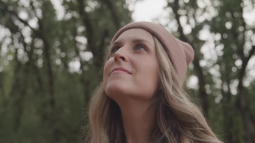 A woman smiles looking up