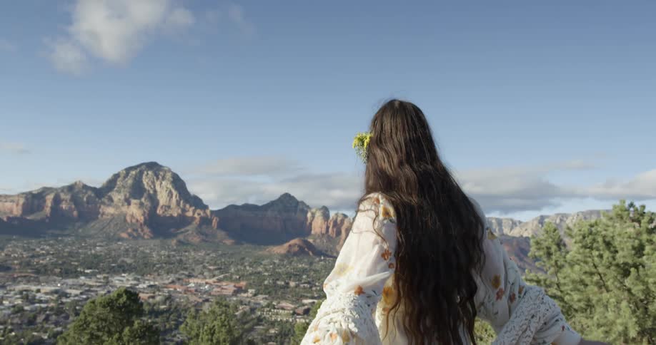 A woman is pointing and laughing at a view on a sunny day