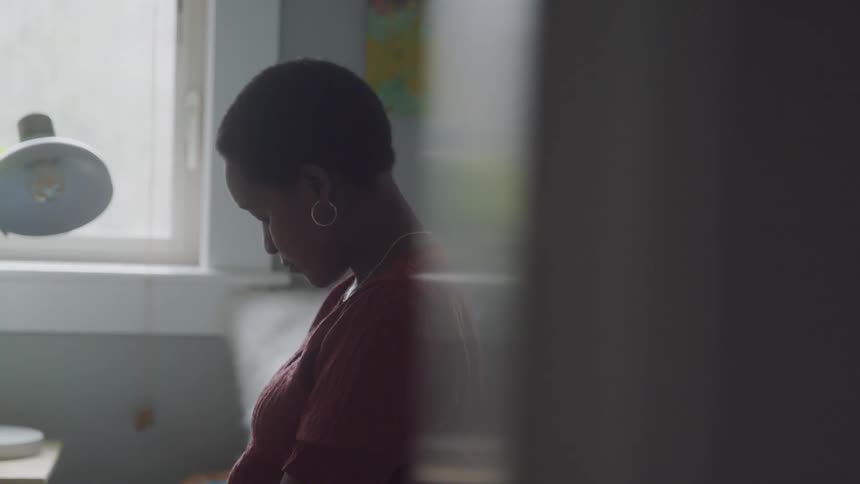 Woman sitting with her head down in a room of the house