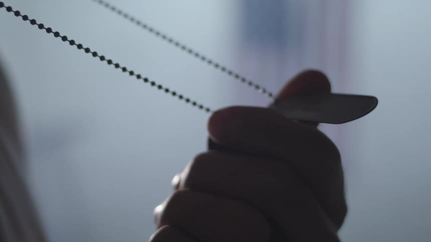 Close up of a hand holding a necklace
