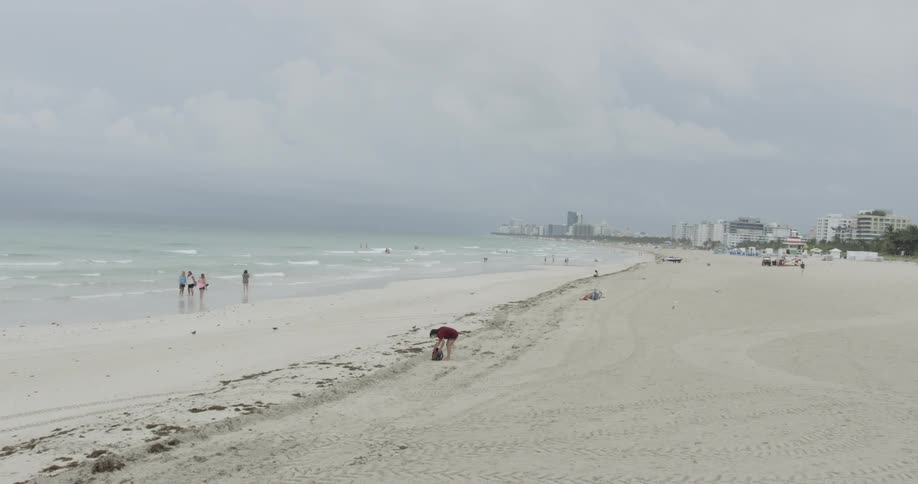 People are on a beach on a cloudy day