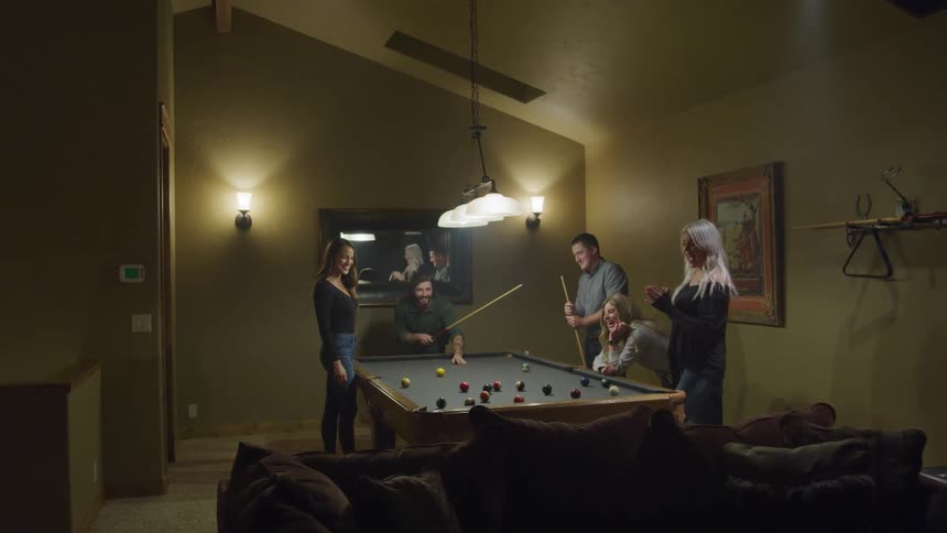 Group of friends playing pool in a living room
