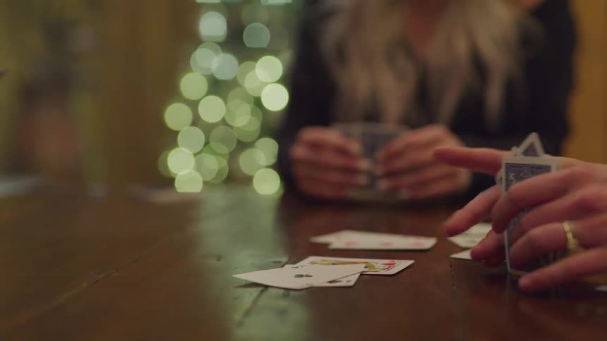 Hands on the table shuffling cards from a deck