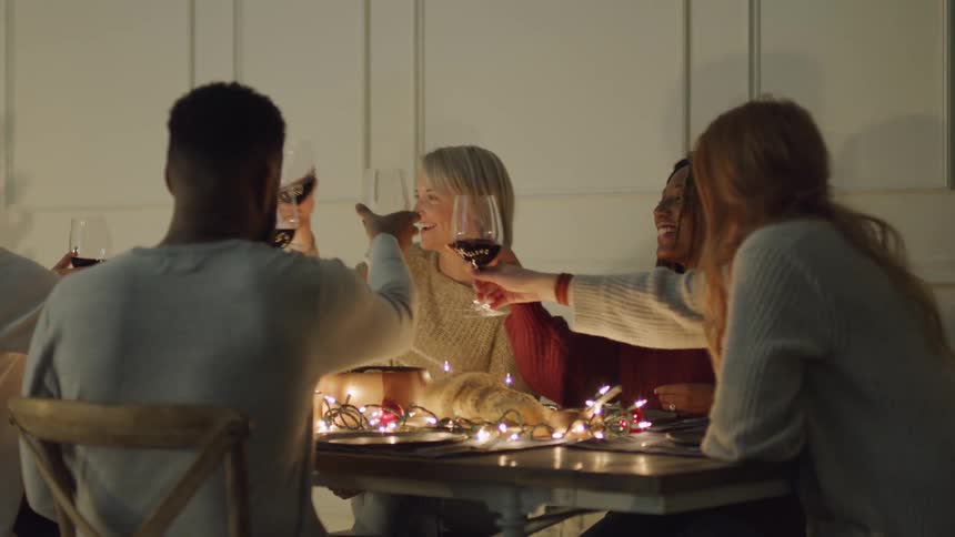 Friends sitting at a table toasting glasses of wine