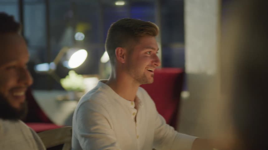 Group of friends sitting at a dinner table talking