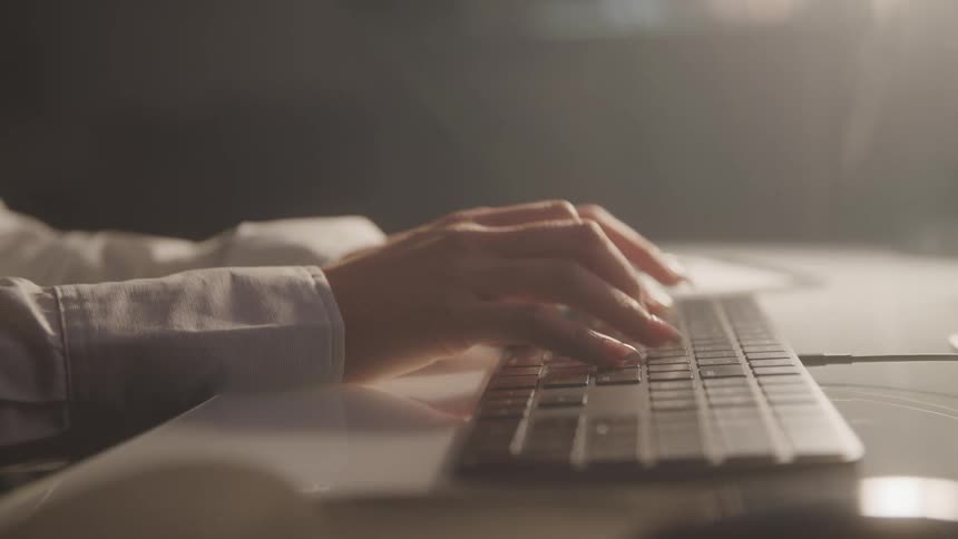 A woman is typing on the keyboard