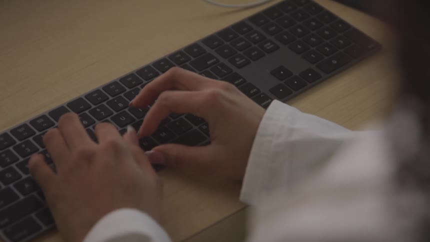 A woman is typing on the keyboard