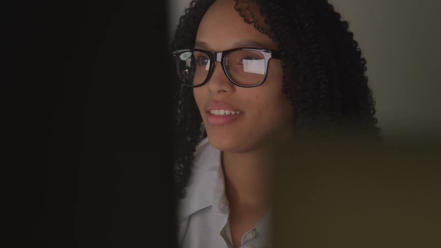 A woman is looking at a computer in the office