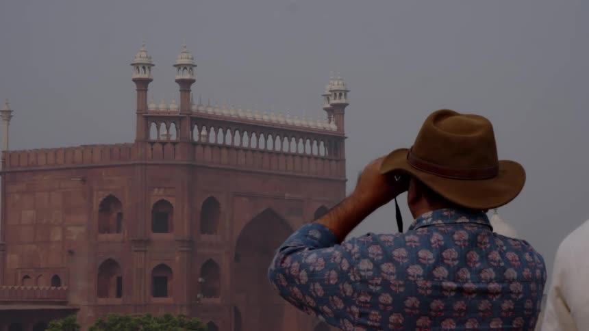 A filmmaker views a historical building in delhi through a lens