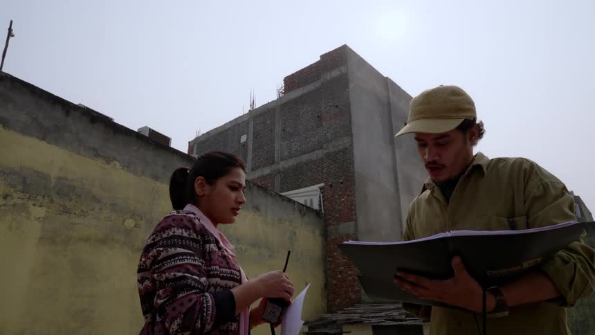 Man and woman with a notepad at an outdoor construction site