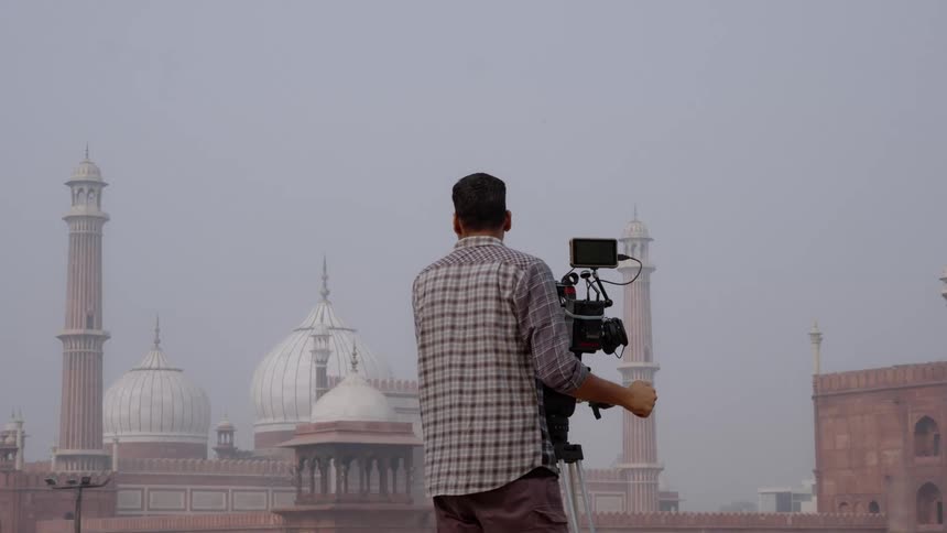 A film crew readies a camera to film a historical building in delhi