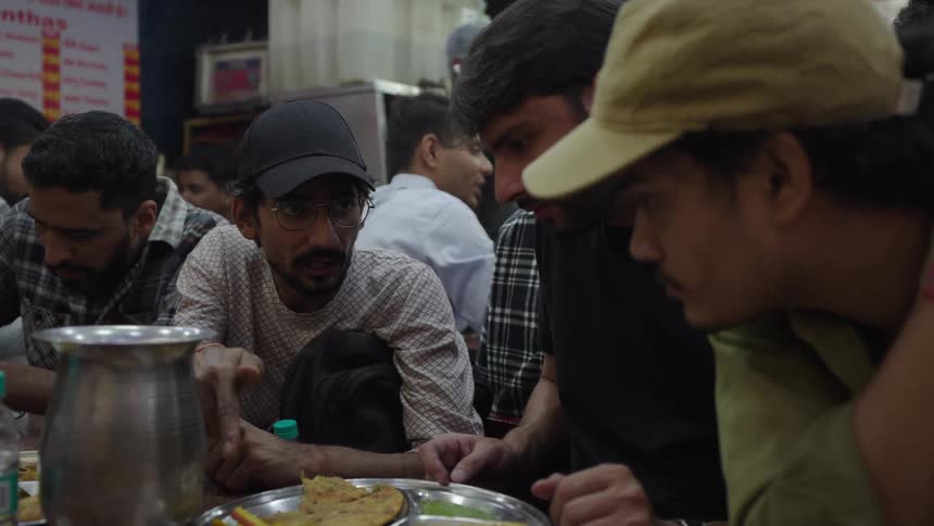 Several men are casually eating together at a table