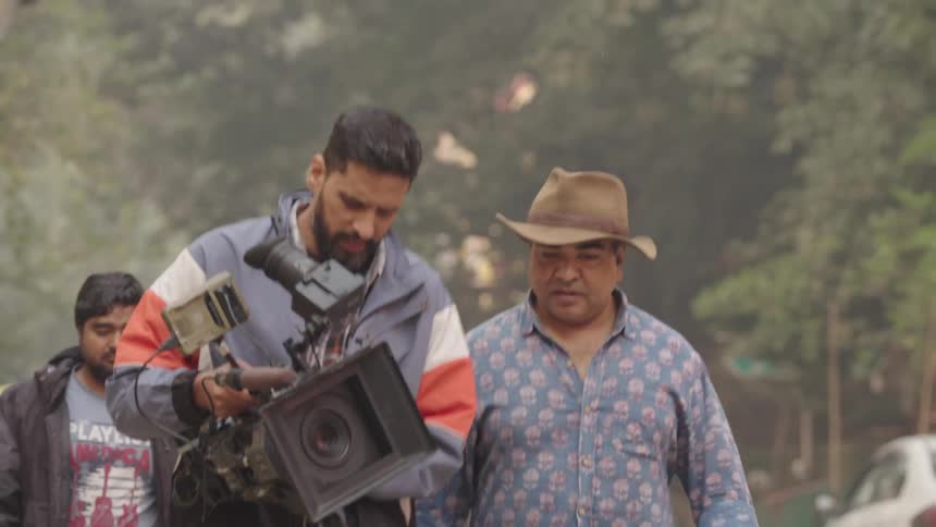A film crew carrying a camera on a city street